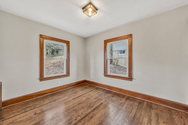 spare room featuring hardwood / wood-style flooring and plenty of natural light