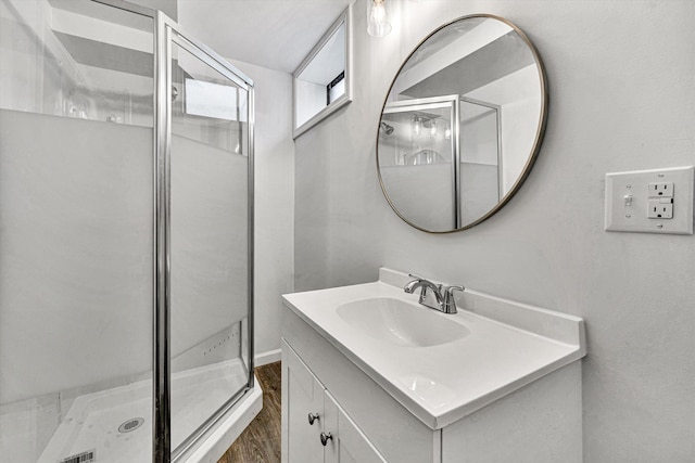 bathroom with hardwood / wood-style flooring, vanity, and an enclosed shower