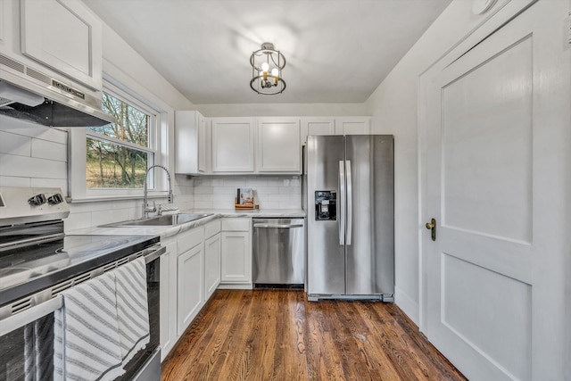 kitchen featuring dark wood-type flooring, sink, appliances with stainless steel finishes, white cabinets, and backsplash