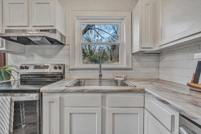 kitchen featuring stainless steel range with electric stovetop, sink, decorative backsplash, and white cabinets