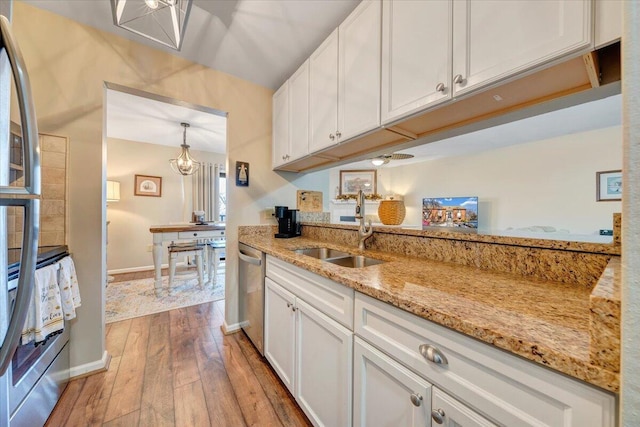 kitchen with light stone counters, sink, and white cabinets