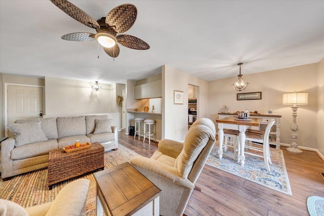 living room featuring ceiling fan and light hardwood / wood-style floors