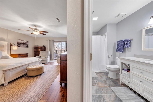 bathroom featuring vanity, ceiling fan, a shower with curtain, and toilet