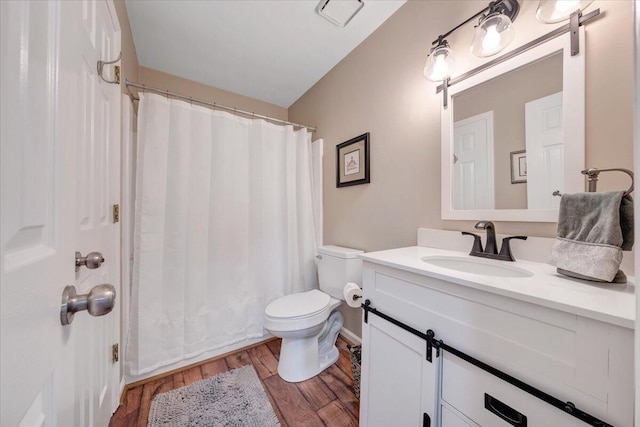 bathroom featuring vanity, toilet, and hardwood / wood-style floors