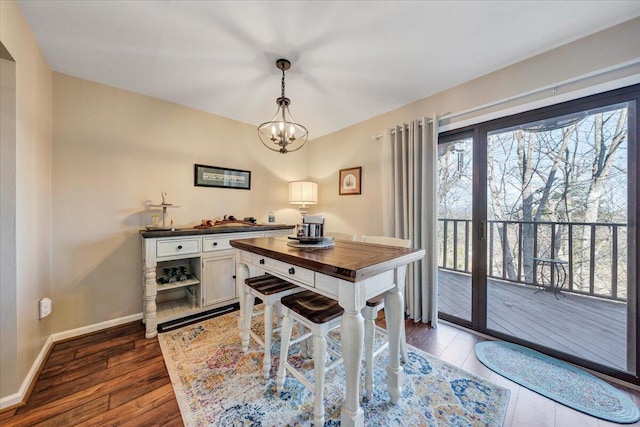 dining space featuring dark hardwood / wood-style floors and a chandelier