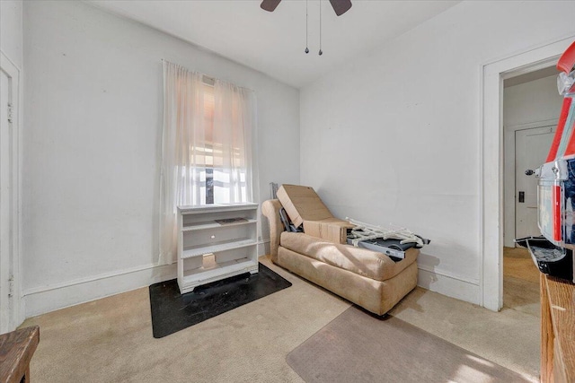 living area with light colored carpet and ceiling fan