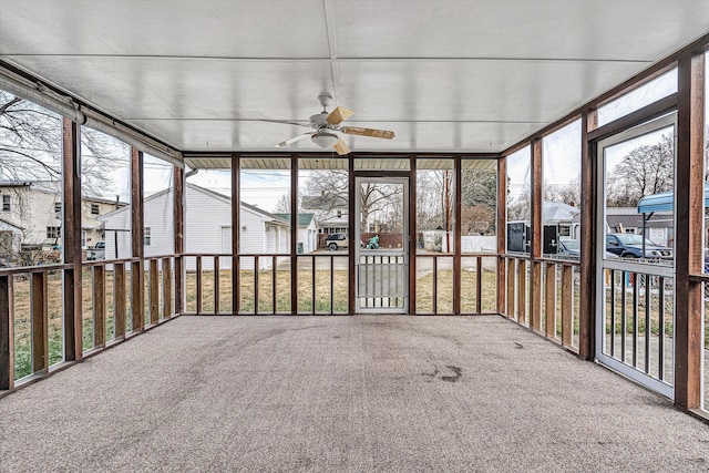 unfurnished sunroom with ceiling fan