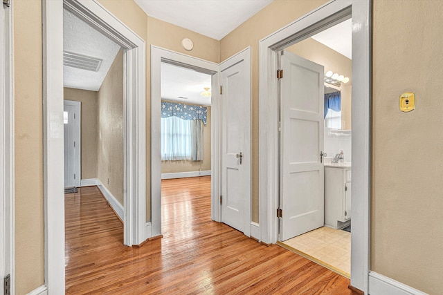 corridor with light hardwood / wood-style floors