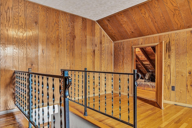 hall with wood-type flooring and wood walls