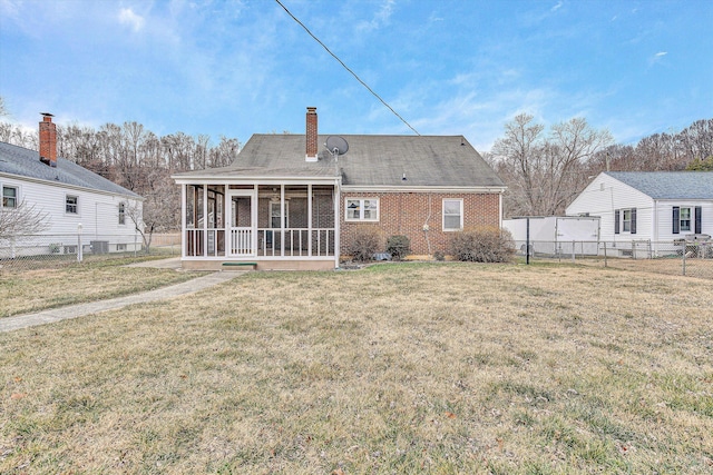 back of house featuring a lawn and a sunroom