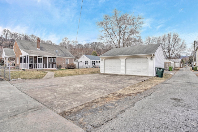 view of side of home with a garage, a sunroom, and a lawn