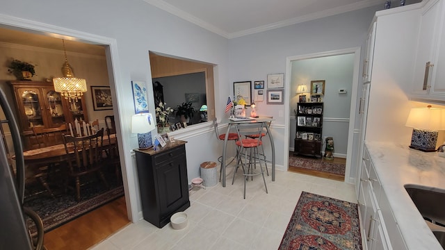 interior space featuring light tile patterned floors, white cabinetry, a notable chandelier, ornamental molding, and decorative light fixtures