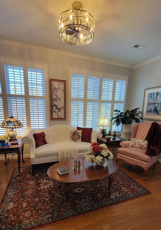 living room featuring crown molding, wood-type flooring, and a chandelier