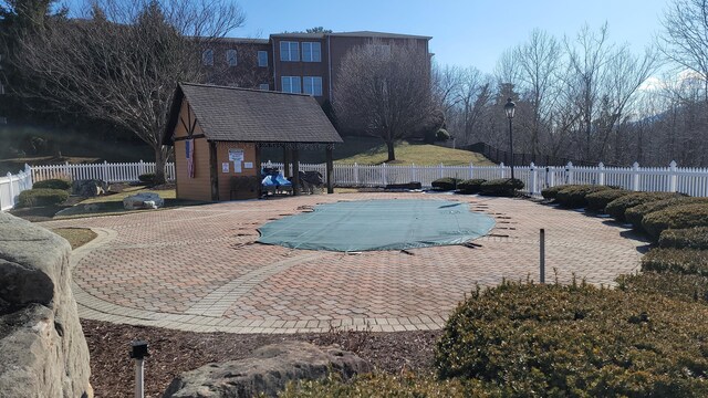 view of swimming pool featuring a water view and a patio area