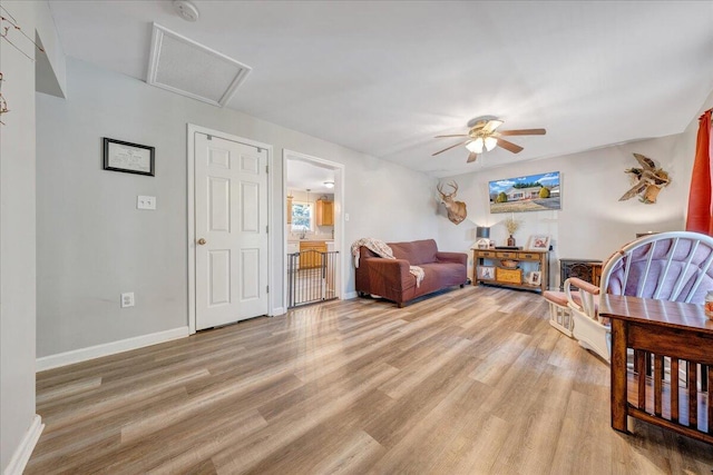 living room featuring ceiling fan and light hardwood / wood-style flooring