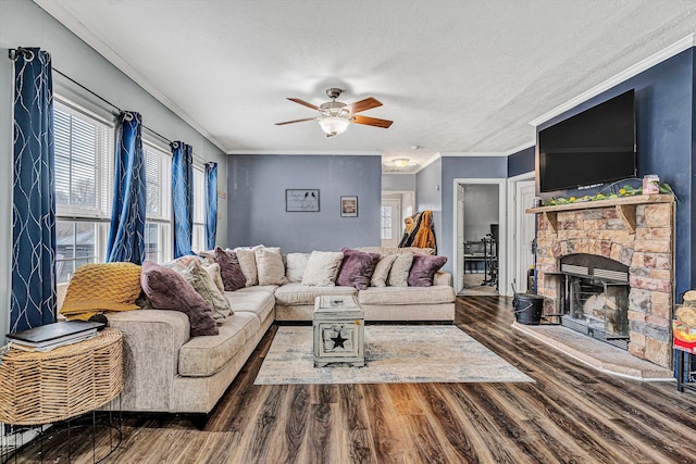 living area featuring crown molding, a fireplace, wood finished floors, a textured ceiling, and a ceiling fan