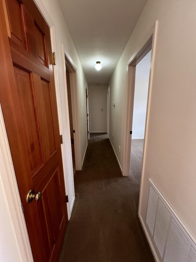 hallway with dark colored carpet