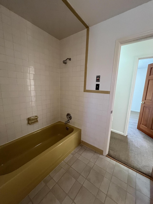 bathroom with tiled shower / bath combo, tile walls, and tile patterned floors