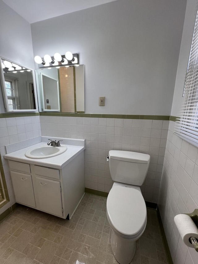 bathroom featuring vanity, tile walls, tile patterned floors, and toilet