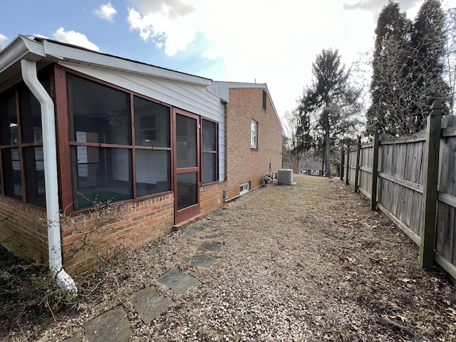 view of side of home featuring a sunroom and central AC unit