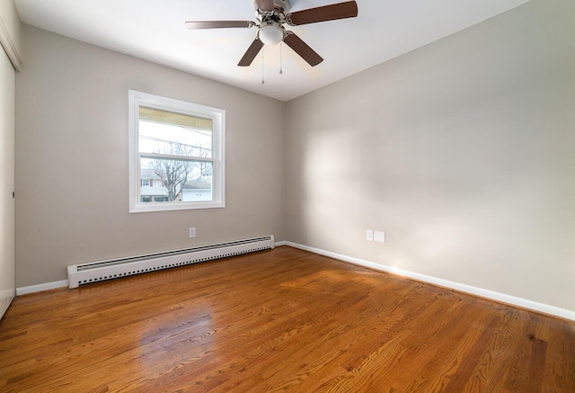 empty room with hardwood / wood-style flooring, a baseboard heating unit, and ceiling fan