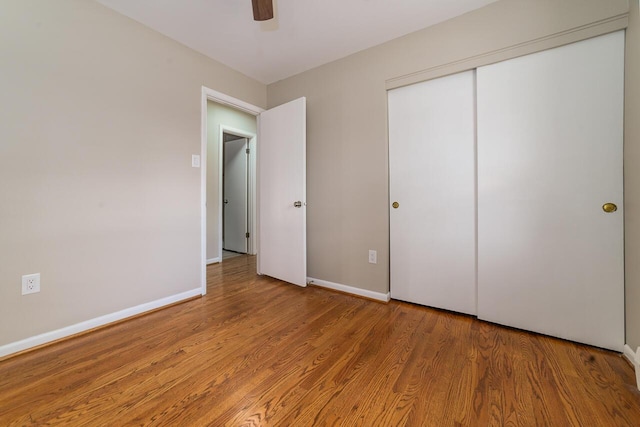 unfurnished bedroom featuring wood-type flooring, a closet, and ceiling fan