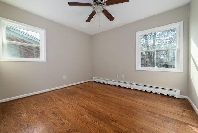 unfurnished room with a baseboard heating unit, wood-type flooring, and ceiling fan