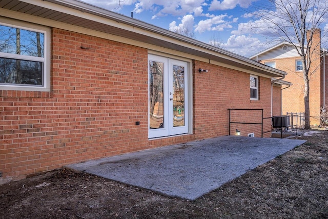 back of property with french doors, a patio area, and central air condition unit