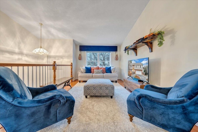 living room with wood-type flooring, lofted ceiling, and a notable chandelier