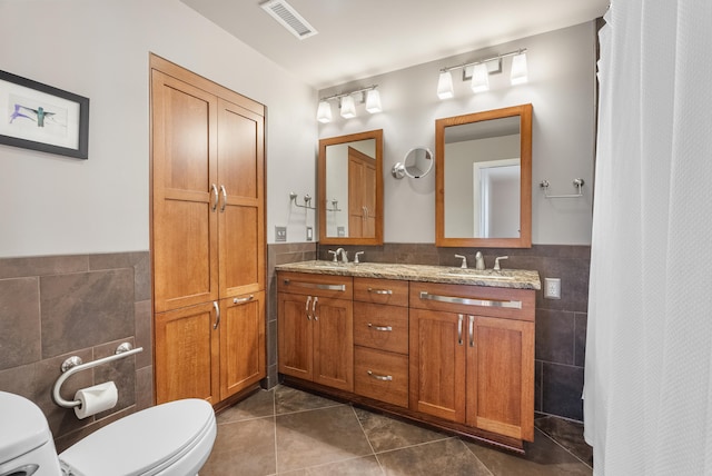 bathroom with vanity, tile walls, tile patterned floors, and toilet