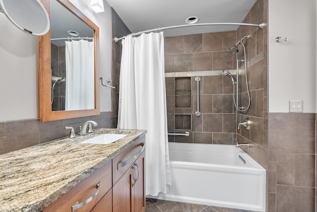 bathroom featuring shower / bath combination with curtain, vanity, tile patterned flooring, and tile walls