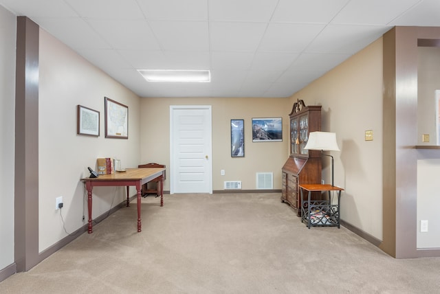 miscellaneous room with a paneled ceiling and light colored carpet