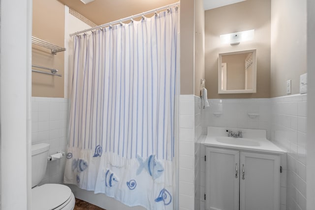 full bathroom with vanity, toilet, tile walls, and shower / bath combo