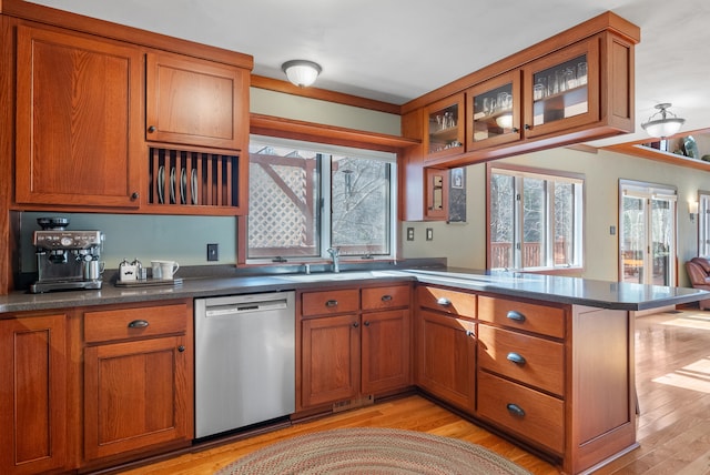 kitchen featuring stainless steel dishwasher, kitchen peninsula, and light hardwood / wood-style flooring