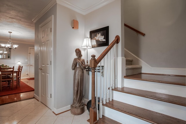 stairway featuring tile patterned flooring, a notable chandelier, baseboards, and ornamental molding