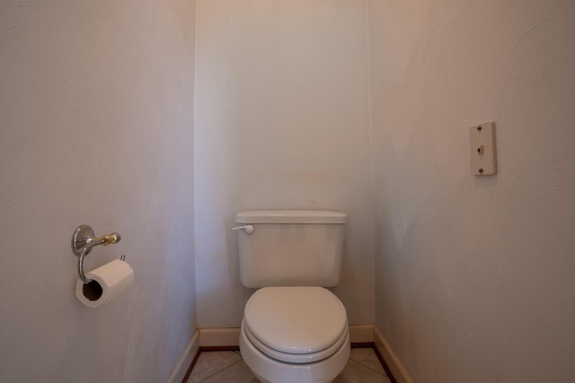 bathroom featuring tile patterned floors, baseboards, and toilet