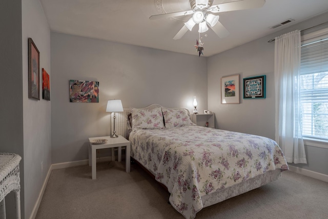 carpeted bedroom with a ceiling fan, baseboards, and visible vents