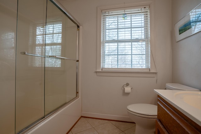 bathroom featuring vanity, baseboards, shower / bath combination with glass door, tile patterned flooring, and toilet