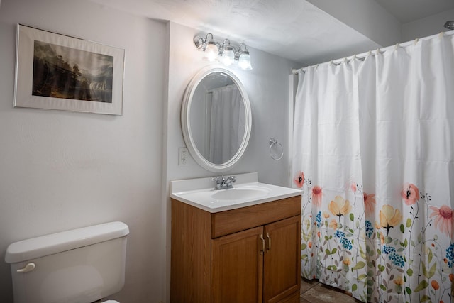 bathroom with vanity, curtained shower, and toilet