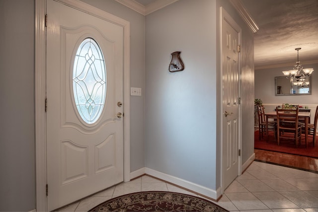 entrance foyer with baseboards, a notable chandelier, light tile patterned flooring, and ornamental molding