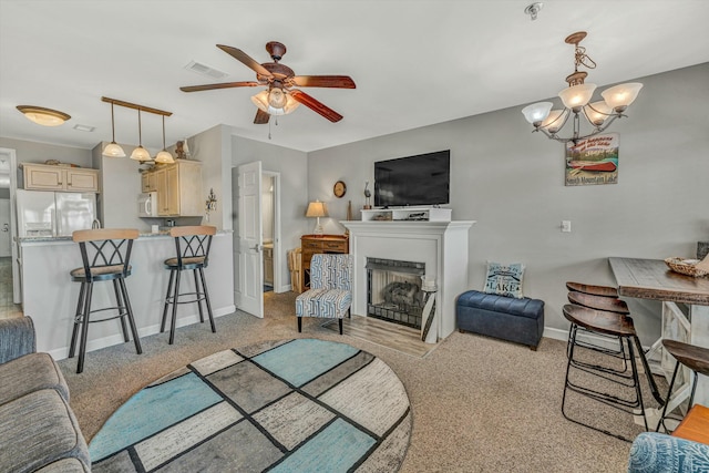 living room with ceiling fan with notable chandelier