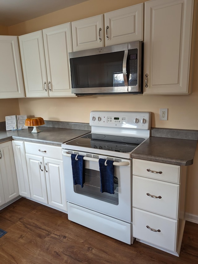 kitchen with electric stove, white cabinetry, and dark wood-type flooring