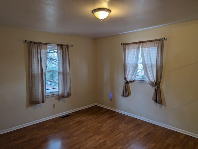 spare room with dark wood-type flooring