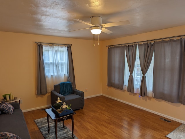 sitting room with wood-type flooring and ceiling fan