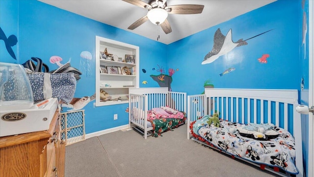 bedroom featuring a nursery area and ceiling fan