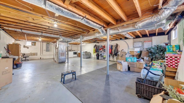 basement with washer / clothes dryer, heating unit, and electric panel