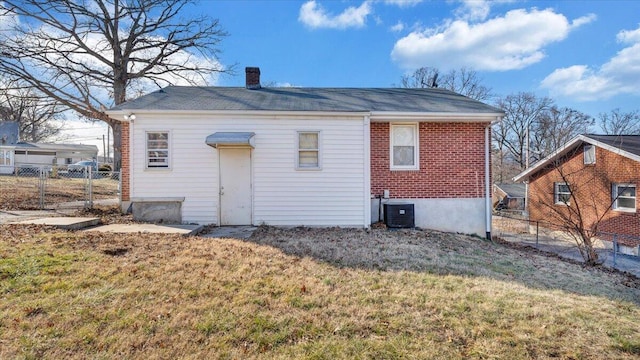 rear view of house with a yard and central AC