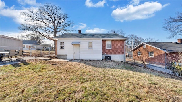 rear view of property with a yard and central AC unit