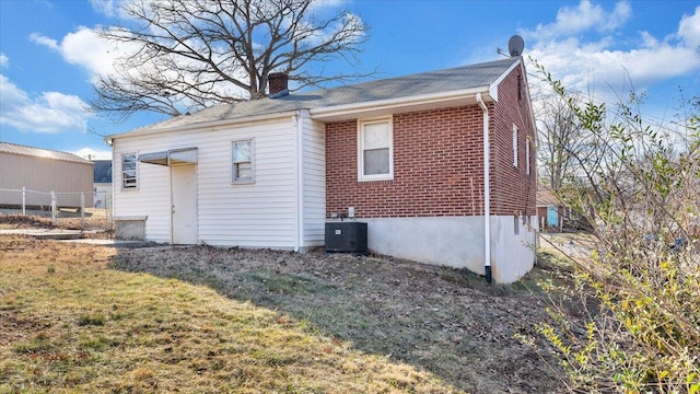 rear view of house featuring central AC and a yard