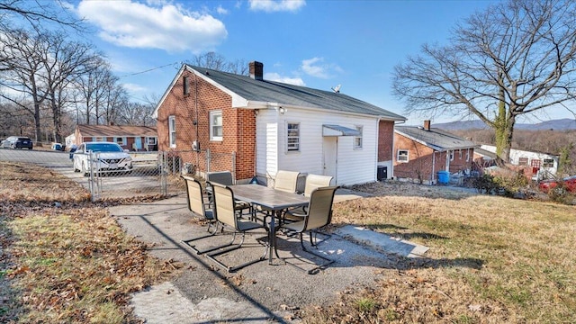 rear view of property with a patio and a lawn